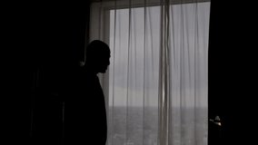 Silhouette Of Male Anxiously Pacing Back And Forth In Apartment Beside Curtains. Static Shot - Powered by Shutterstock - Get 15% off with code: PIKWIZARD15