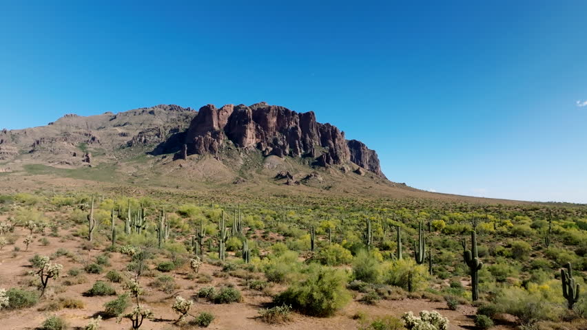 Establishing dolly above dry arid desert southwest cactus land to Superstition Mountains Royalty-Free Stock Footage #3445102883