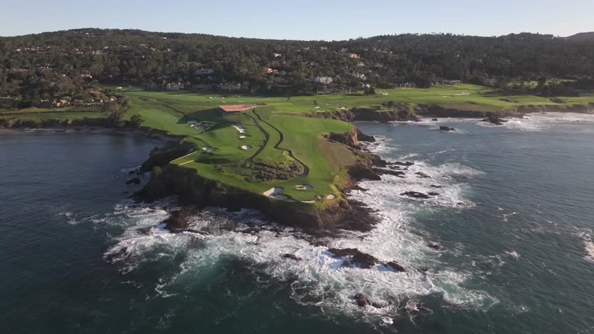Famous Pebble beach golf course over 7th hole, cinematic aerial view over ocean at sunrise