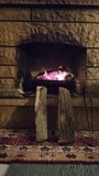 Burning wood in brick fireplace. Fireplace with a blazing fire. Hot fire in darkness on fireplace. vertical video for social media.	
