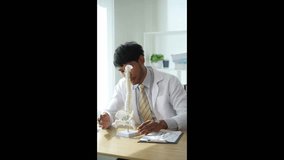 Young doctor explains the functions of internal human organs over the internet, medical health concept online. Vertical video