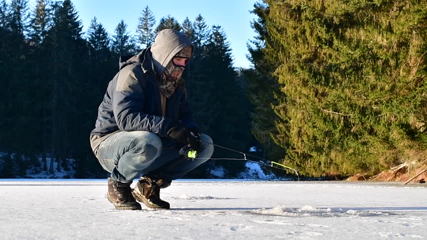 Ice fisherman fishing for lake trout, winter activities