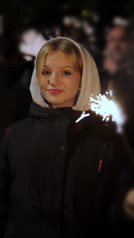 Vertical.Party at night, happy teenager girl with sparkler, happy birthday or new year