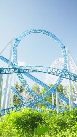 Roller coaster Ride against blue sky. Roller coaster in the amusement park. Cheerful entertainments in park of attractions