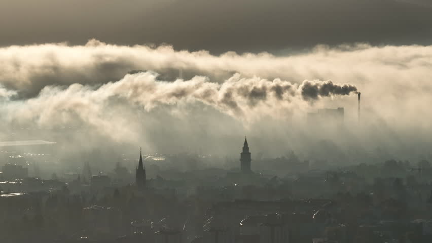 Bielsko-Biala cityscape silhouette emerging through fog cloud and pollution smog covering southern Poland landscape