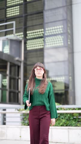 portrait beautiful young caucasian businesswoman walking holding a digital tablet in the street	