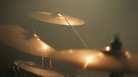 Close-up drummer hands hit the drum cymbal with drumstick in a dark studio. Drummer plays the drums in the recording studio. Music band rehearsal - Powered by Shutterstock - Get 15% off with code: PIKWIZARD15