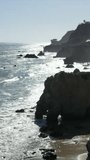 Vertical frame layout of beautiful abstract silhouette 4K video over Malibu, California. People on beach enjoying their holidays and vacations. Rocks, cliffs, waves, Nature, sstkVertical, b-roll, ads.