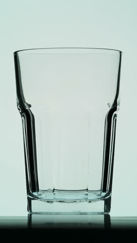 pouring water in a transparent glass   4k slow motion 240 frames per second vertical video