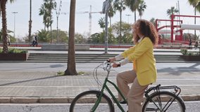 Lateral video of a tourist in Barcelona biking along the maritime promenade