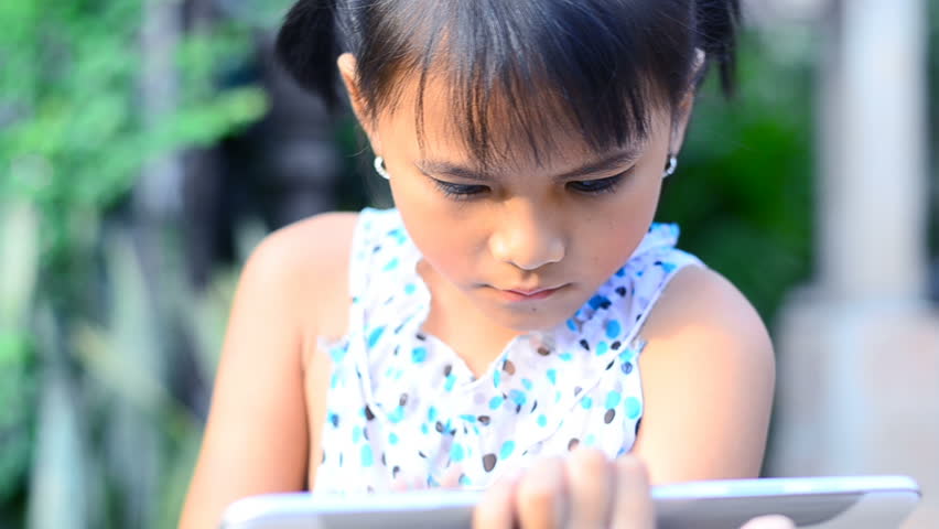 Little girl playing on computer tablet