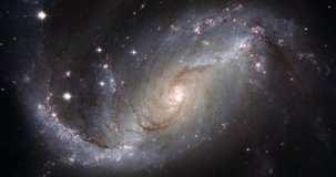 Zoom in on a spiral galaxy in the Dorado constellation. Colourful universe, cosmos, outer space with rotating galaxies, stars, planets against the dark void. Video based on images by NASA and ESA.