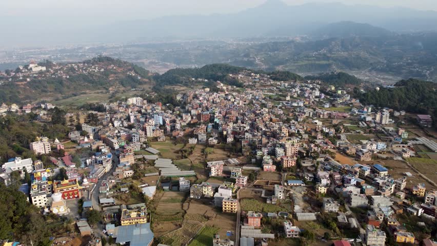 Aerial view of Kathmandu city, Nepal, showcasing the densely packed buildings and the majestic Himalayan mountains in the background.