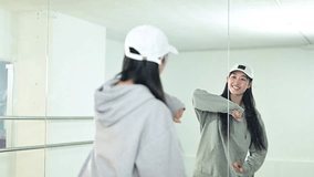 Cheerful Asian female dancer filming a video tutorial for social media in studio