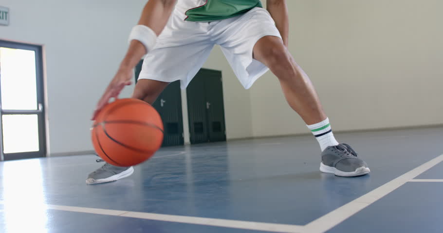 Young biracial man plays basketball indoors. Athleticism shines as he dribbles the ball on the court, slow motion. Royalty-Free Stock Footage #3445767145