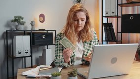 Caucasian young woman freelancer counting cash insufficient amount of money. Financial crisis. Bankruptcy. Poverty and destitution. Female girl businesswoman with laptop sitting at home office table. - Powered by Shutterstock - Get 15% off with code: PIKWIZARD15