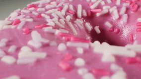 Close up of a pink donut with sprinkles. Macro. - Powered by Shutterstock - Get 15% off with code: PIKWIZARD15