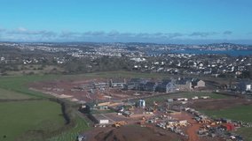 Paignton, Torbay, South Devon, England: DRONE VIEWS: A new build housing construction site on green belt land on the outskirts of Paignton (Clip 1)
