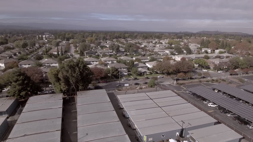 Aerial Tilt Down Shot Of Warehouses And Roofed Houses In City Under Cloudy Sky - San Jose, California