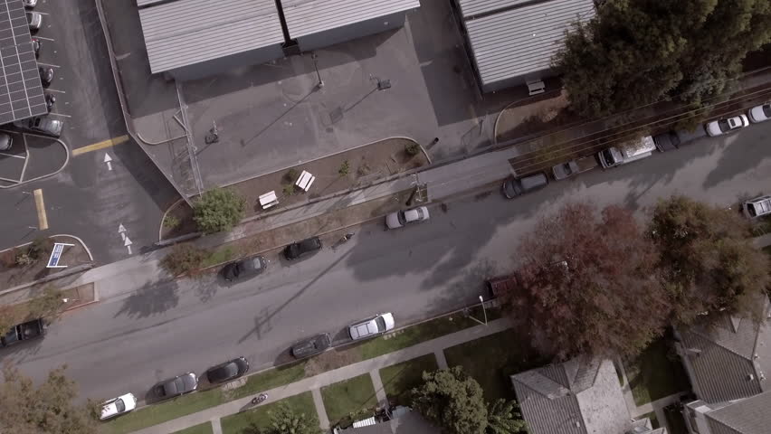 Aerial: Drone Descend Tilt Up Shot Of Cars Parked On Road By Warehouses During Sunny Day - San Jose, California Royalty-Free Stock Footage #3445964197