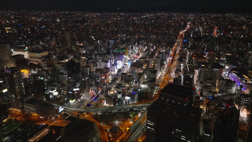 Aerial footage of Dotonbori urban district glowing into night. Popular tourist and nightlife area. Panoramic view of night metropolis. Osaka, Japan