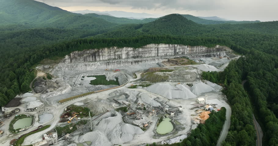 Aerial view of open pit mining site of limestone materials extraction for construction industry.