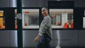 Happy voyager walking platform near modern high-speed train. Confident short hair woman carrying luggage arrived to destination. Smiling young girl hipster going on railway station looking camera. - Powered by Shutterstock - Get 15% off with code: PIKWIZARD15