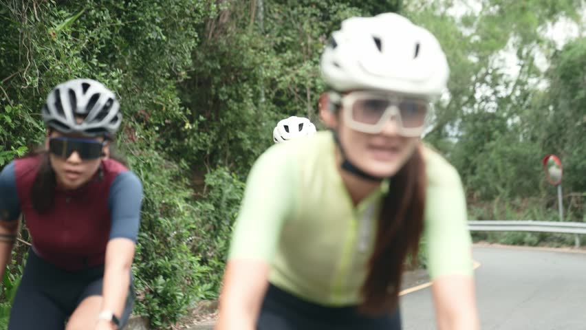 young asian adult cyclists riding bike on rural road