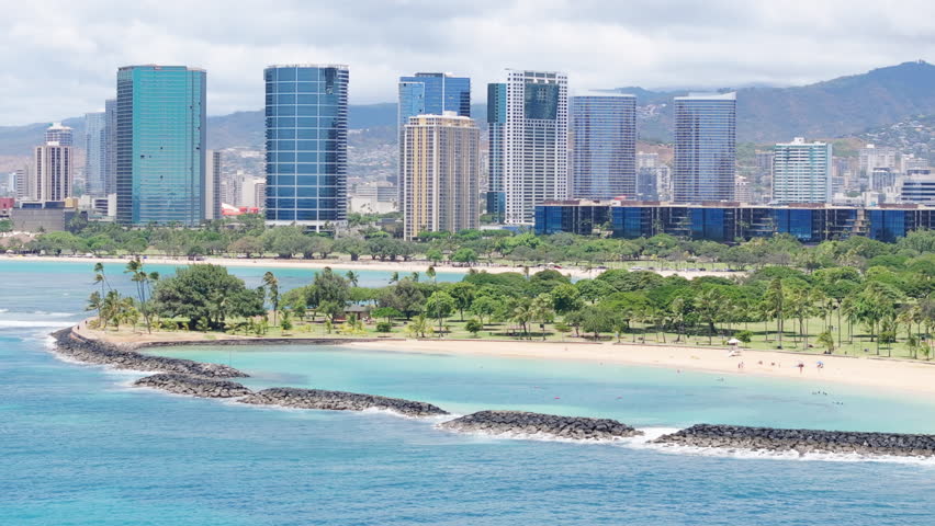 Cinematic aerial Honolulu beach, Oahu island. Modern city on summer day on mountain background. Real Estate business modern glass buildings. Prestige residential ocean view beach front property Hawaii Royalty-Free Stock Footage #3446159159