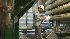 Engineer looking a job of maintenance works in the document paper , activity works in industrial factory , video for industrial business concept