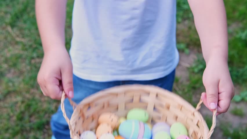 Easter Egg Hunt.Child collects Easter eggs and puts in a basket. Eggs in a round basket on a green clover.View from above. Colorful easter eggs. Easter holiday tradition.Spring religious holiday Royalty-Free Stock Footage #3446217593