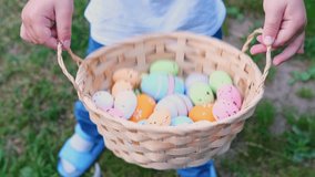 Easter Egg Hunt.Child collects Easter eggs and puts in a basket. Eggs in a round basket on a green clover.View from above. Colorful easter eggs. Easter holiday tradition.Spring religious holiday - Powered by Shutterstock - Get 15% off with code: PIKWIZARD15