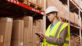 A girl in a hard hat with a telephone in a warehouse