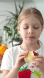 A child chews an appetizingly large apple. Seasonal fruit. Natural and healthy nutrition for children and adults. Fresh fruits. Healthy teeth and a beautiful smile. healthy lifestyle