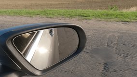 Video shooting in motion, view in the rear view side mirror of a auto
