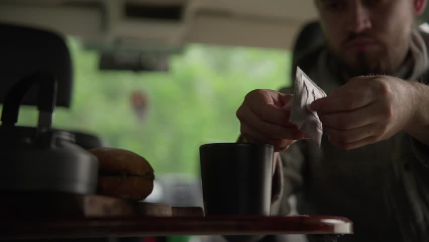 Pouring hot water in cup with drip coffee bag. Making coffee drip bag