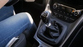 Closeup slow motion video of young woman driving car with manual gearbox