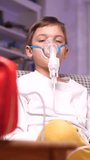vertical video a boy is doing a inhaler, nebulizer treatment in his room. 