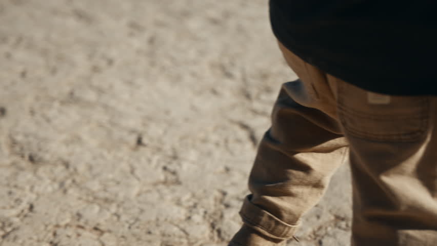 A boy walking in super slow motion dressed in boots and safari clothes through the famous Deadvlei Desert on a beautiful sunrise in Sossusvlei, Sesriem, Namibia, Africa Royalty-Free Stock Footage #3446455063