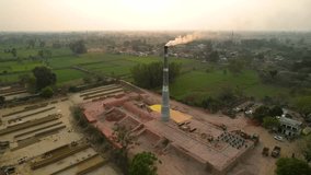 Aerial drone shot of a brick kiln factory where they are baking clay into bricks used for construction at sunset
