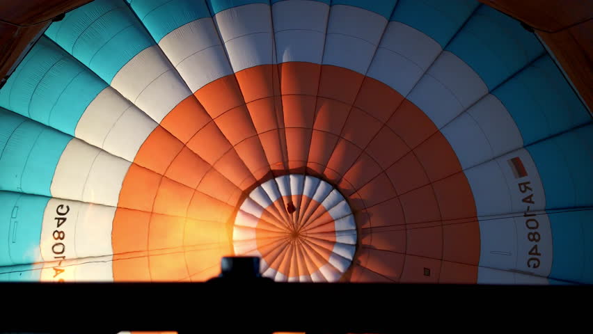 Slow motion close up view of the flame inside of a colorful hot air balloon being inflated before the flight. High quality 4k footage