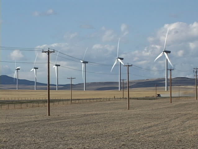 Wind turbines with power lines and passing car