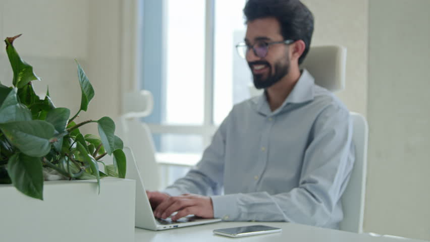 Indian arabian business man male worker manager working online in modern office smiling happy millennial businessman work on computer chatting with clients typing email browsing internet at desktop Royalty-Free Stock Footage #3446517027