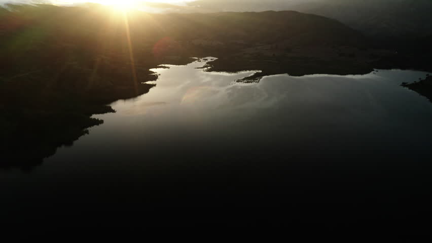 Aerial Forward Tilt Up Shot Of Lake Casitas Near Mountain Against Sky At Sunset - Ventura County, California