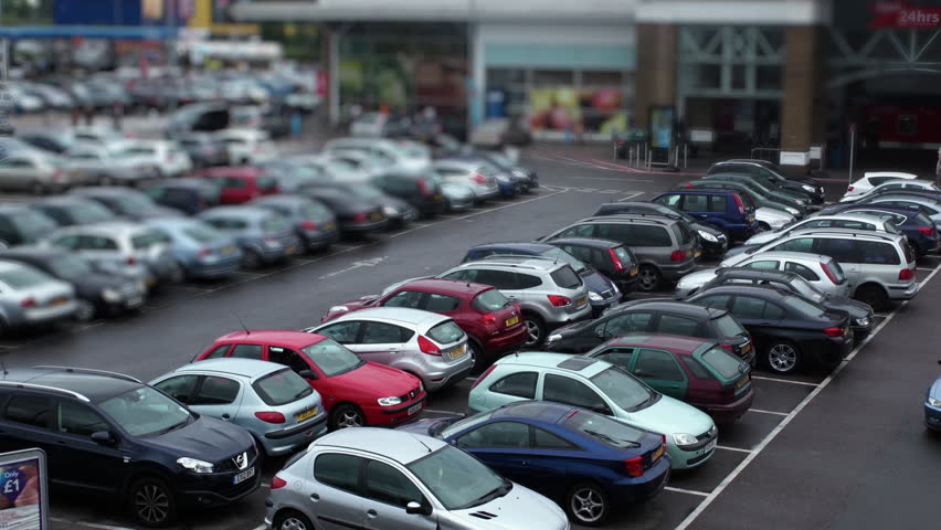 Overhead shot of supermarket parking lot, features shoppers loading groceries into their vehicles. London 2015 Royalty-Free Stock Footage #34465480