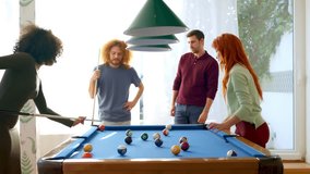 Four friends play pool, with one woman excitedly reacting to sinking a ball, in a room with natural light.  - Powered by Shutterstock - Get 15% off with code: PIKWIZARD15