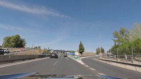 First person view, FPV, from dashcam of car driving in the beautiful Spanish countryside towards Seville, Andalusia, Spain, Europe. Road trip video in POV, with bright, sunny, blue sky
