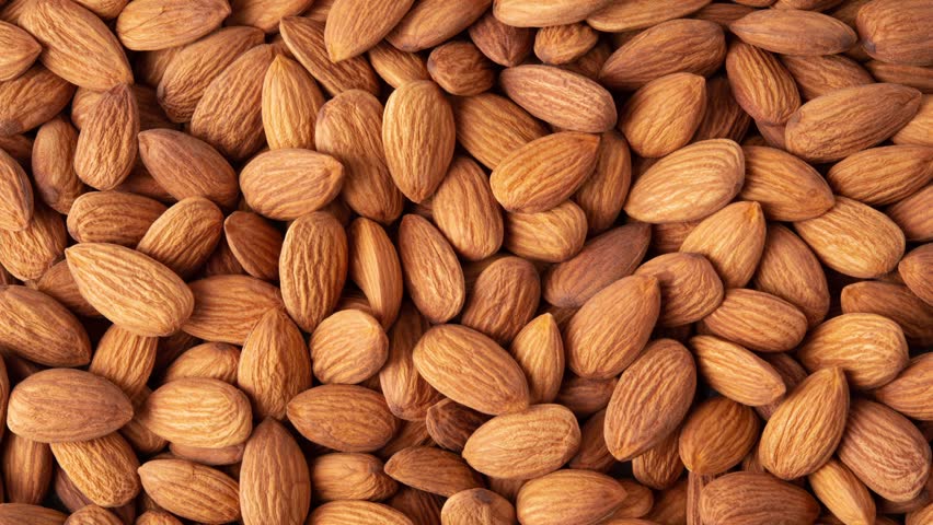 Almond top view 4K video. Almonds top view background. Whole almond nuts flat lay. Royalty-Free Stock Footage #3446627753
