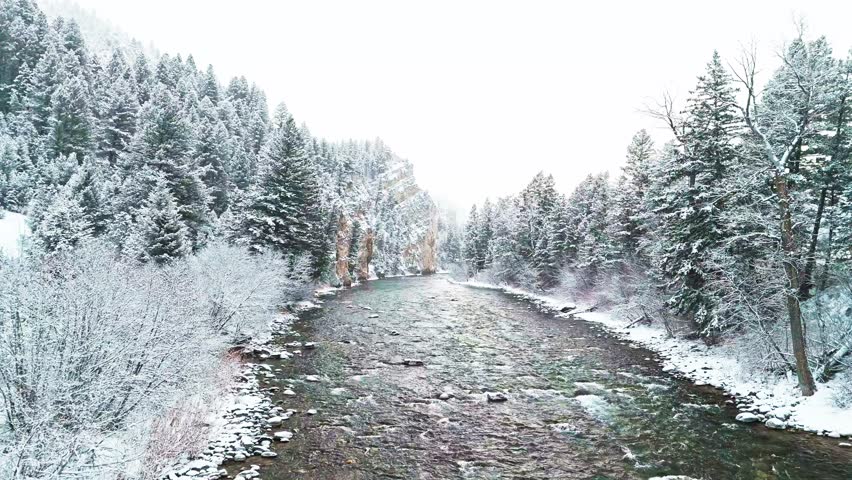 Mountain river flowing through canyon during snowstorm along the road in Montana