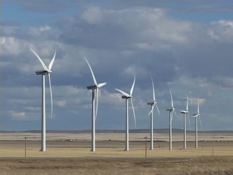 Row of seven wind turbines with passing truck
